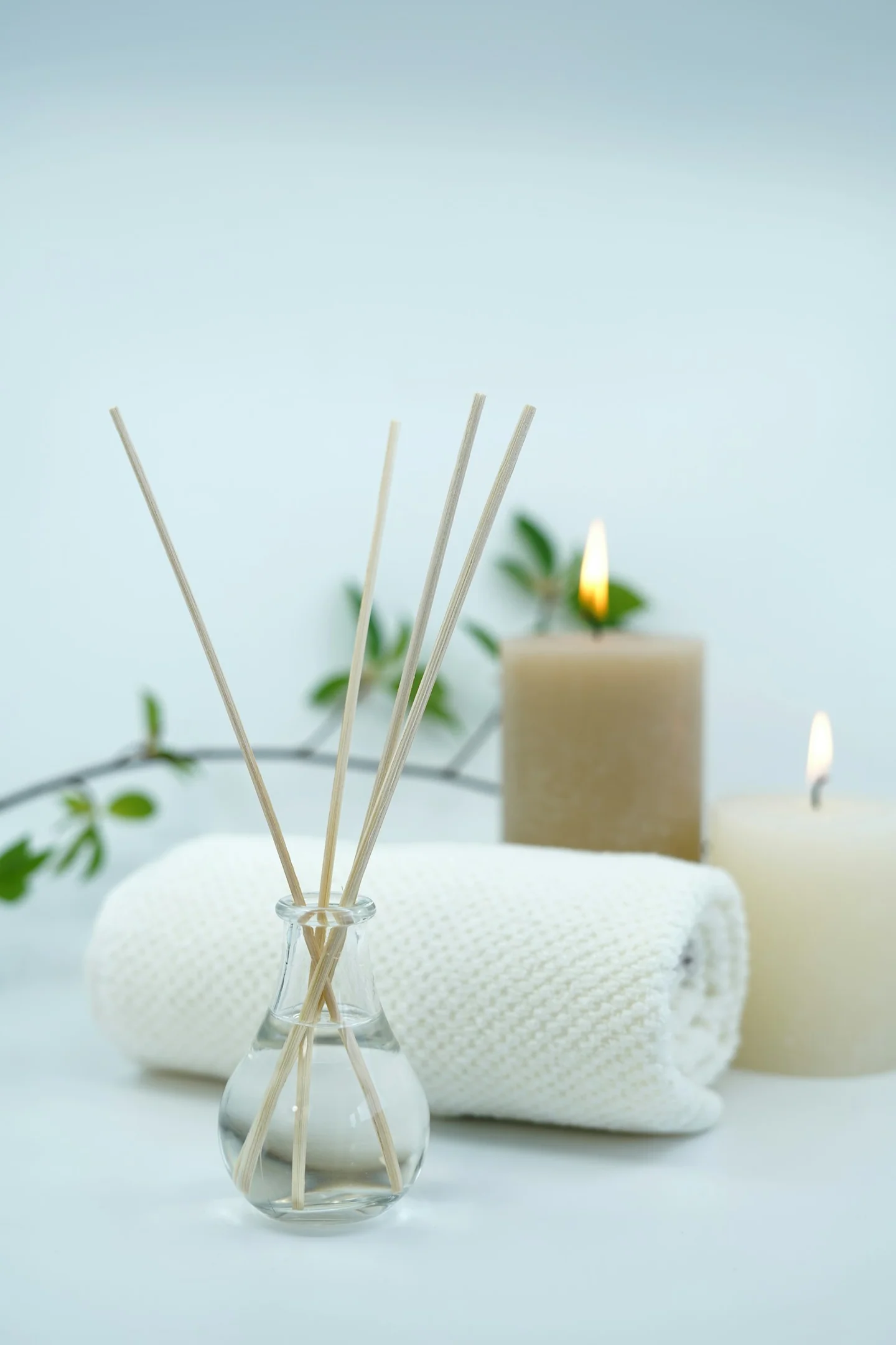 Spa towel, candles and diffuser arranged for a massage setting