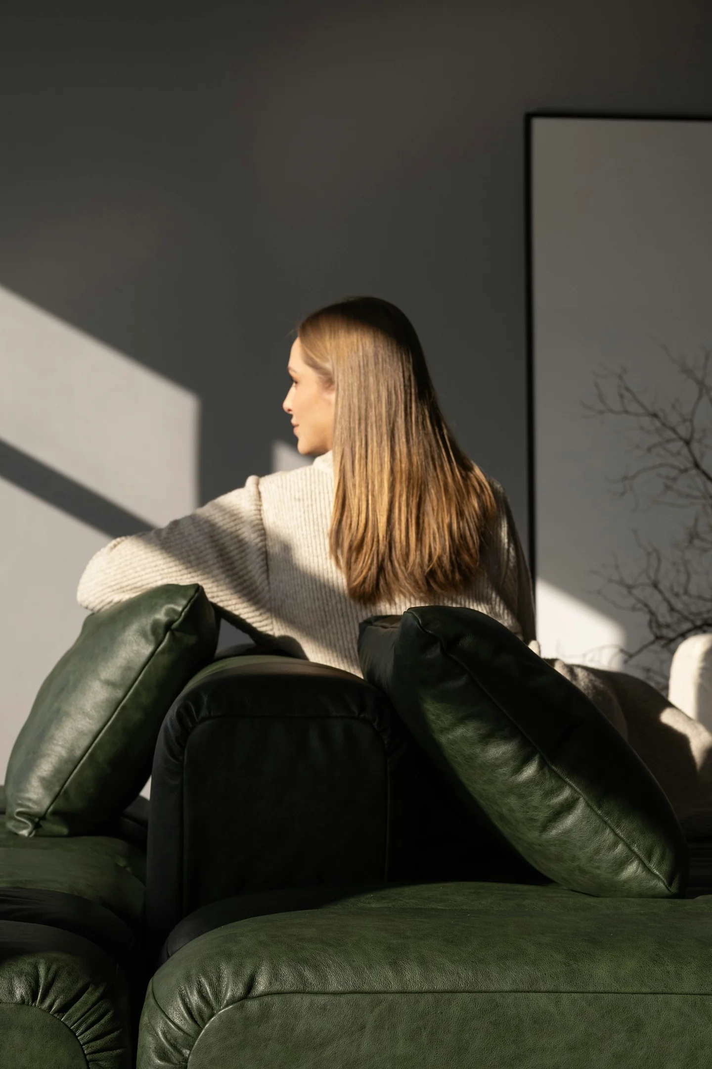 Woman sitting on a couch in a modern apartment living room