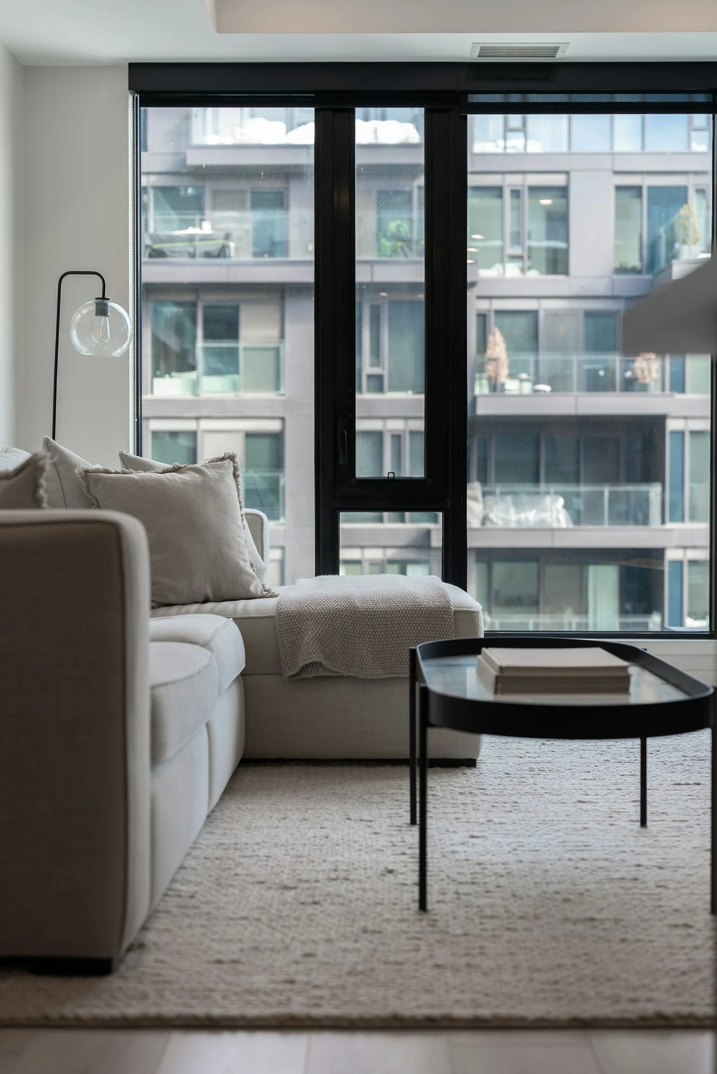 Modern apartment living room with large windows and a city view